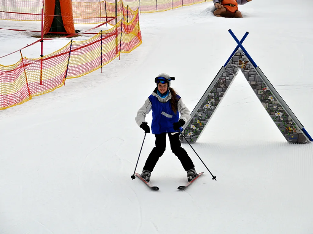 Skifahrerin fährt auf das Übungstor zu.